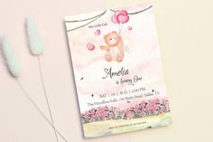 a pink teddy bear with balloons is on the card