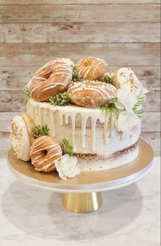 a cake with frosting, flowers and donuts on top