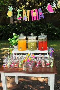 a table topped with lots of drinks on top of a wooden table covered in fruit