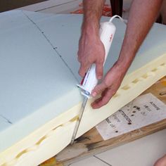 a man is using a knife to cut up a mattress