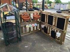 an outdoor play area with potted plants and chalkboards