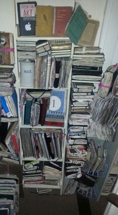 a book shelf filled with books next to a wall covered in files and folders