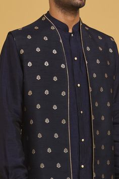 Navy blue silk nehru jacket with floral motifs applique embroidery. Comes with off-white cotton silk straight pant and a kurta.
Components: 3
Pattern: Applique embroidered
Type Of Work: Floral motifs
Neckline: Mandarin collar
Sleeve Type: Nehru Jacket: Sleeveless, Kurta: Full
Fabric: Silk, Pant: Cotton silk
Color: Blue
Other Details: 
Closure:
Kurta: Pearl buttons
Pant: Front fly and zip
Occasion: Sangeet - Aza Fashions Formal Nehru Jacket With Floral Embroidery And Straight Cut, Blue Nehru Jacket With Intricate Embroidery For Diwali, Formal Nehru Jacket With Floral Embroidery And Straight Fit, Formal Straight Nehru Jacket With Floral Embroidery, Designer Bandhgala With Gold Embroidery In Chanderi, Diwali Blue Nehru Jacket With Intricate Embroidery, Festive Designer Nehru Jacket With Stand Collar, Blue Chanderi Long Sleeve Bandhgala, Blue Long Sleeve Chanderi Bandhgala