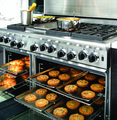 an oven with several trays of cookies and muffins cooking in the oven