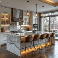 a kitchen with marble counter tops and bar stools next to an open living room