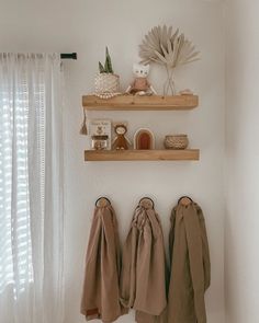 two wooden shelves with coats hanging on them