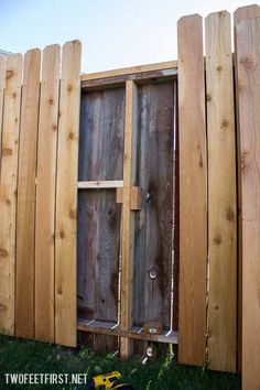 a wooden fence that has been built into the side of it with some tools in front of it