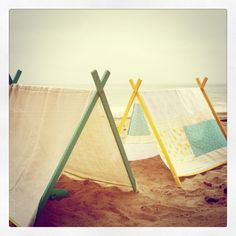 three different colored clothes hanging on the beach