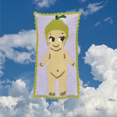 there is a cross stitch picture hanging on the clothes line in the sky with clouds behind it