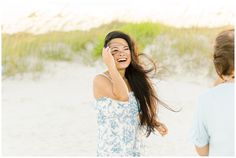 a woman is laughing while talking on her cell phone with another woman in the background