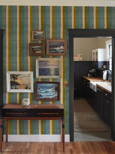 an entry way leading to a kitchen and dining room with striped wallpaper on the walls