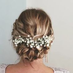 the back of a woman's head wearing a white flowered bridalt