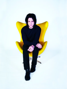 a man sitting in a yellow chair with his legs crossed