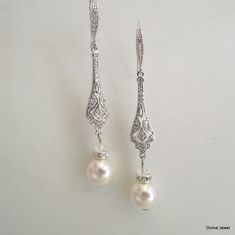 "These art deco style earrings have the perfect amount of sparkle to complement any gown. They have 10 mm Swarovski pearls in your choice of color. Earrings have vintage style filigrees with pave stones and cubic zirconia teardrops. They measure about 2 1/2\" long from top to bottom. Ear wire has tiny cubic zirconia stones set it for a perfect complement! They are perfect for your vintage inspired wedding or any special occasion! Most of my styles can be customized, just ask please =)" Bridal Pearl Earrings, Bridal Earrings Chandelier, Earrings Chandelier, Pearl Earrings Wedding, Color Earrings, Bridal Earrings Pearl, Vintage Inspired Wedding, Rhinestone Wedding, Cubic Zirconia Earrings