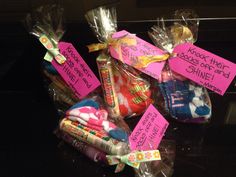 some candy wrapped in plastic bags with pink notes on them and writing on the side