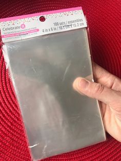 a hand is holding up a clear plastic envelope