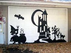 a garage with a mural on the side of it that has bats and witches painted on it