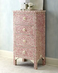 an ornate pink and white chest of drawers in a room with light blue walls,