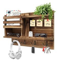 a wooden shelf with keys, sunglasses and headphones hanging on it's sides