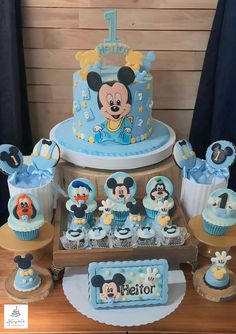 a mickey mouse birthday cake and cupcakes on a table