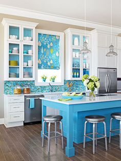 a kitchen with blue counter tops and stools next to an island in the middle