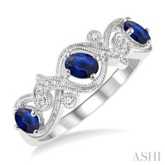 A chic sapphire and diamond precious band, this makes for an instant eye-catcher. It is not only beautifully designed, but also offers a unique wedding band look. The ring features a lovely open Lattice entwined top, with glorious oval cut sapphires nestled within each open window. There are a total of 3 prong set 4x3MM oval cut sapphires embellishing the band. Apart from this, 2 bezel set round cut diamonds and 10 pave hand set round cut diamonds, decorate the entwined top. A milgrain border hi Sapphire And Diamond Band, Unique Wedding Band, Trending Engagement Rings, Engagement Rings Bridal Sets, Unique Wedding Bands, Open Window, Diamond Band, Gemstone Bracelets, Sapphire Diamond