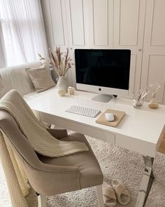 a white desk with a computer monitor and keyboard