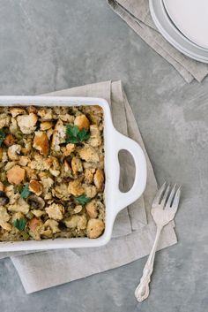 a casserole dish on a napkin with a fork and plate next to it