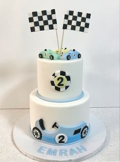 a two tiered cake decorated with cars and checkered flags for a race car themed birthday party