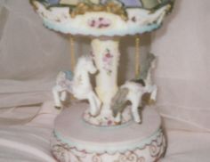 an old fashioned carousel with horses on it's sides and a blue sky in the background