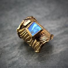 Modern, Brutalist-style Textured Ring. Fully handmade work. 18Ct Gold Plated Bronze. Oxidized. The ring is covered with a protective layer. The main accent of this ring is a natural Rainbow Moonstone. Material: 18Ct Gold Plated Bronze, Rainbow Moonstone. The height of the central part is 3.3 cm. Size: Adjustable. Color: Blue, Antique Gold Unique Untreated Yellow Gold Jewelry, Gold Fusion Style Moonstone Jewelry, Hand Forged Moonstone Jewelry In Yellow Gold, Gold Fusion Moonstone Jewelry, Yellow Gold Moonstone Jewelry, Unique Yellow Gold Moonstone Jewelry, Fusion Style Hand Forged Rings As Gift, Hand Forged Fusion Style Ring As Gift, Hand Forged Fusion Style Rings For Gifts