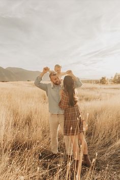 a man and woman standing in tall grass