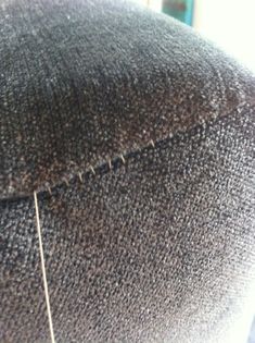 the back of a person's head with hair on top of it and needles in front of them