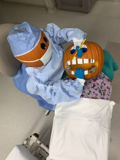 an inflatable pumpkin sitting on top of a bed next to other clothing items