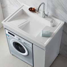 a white sink sitting next to a washer and dryer