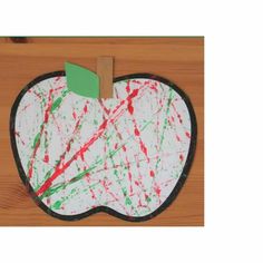 an apple shaped paper plate with paint splattered on it