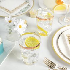 the table is set with plates, silverware, and lemon wedges for dessert