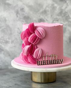 a pink birthday cake with the words happy birthday on it