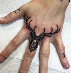 a person's hand with a deer tattoo on it