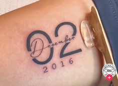 a woman with a tattoo on her thigh that says december 2012 and has the date written in black ink