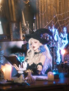 a woman dressed up as a witch sitting at a table with candles in front of her