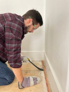 a man in plaid shirt working on floor