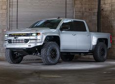 a silver truck parked in front of a building