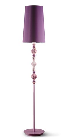 a lamp that is sitting on top of a purple stand with a purple shade over it