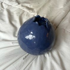 a blue vase sitting on top of a white sheet