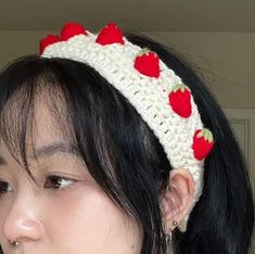 a woman wearing a crocheted headband with strawberries on it