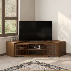 a flat screen tv sitting on top of a wooden entertainment center next to a window