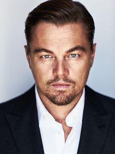 a close up of a person wearing a suit and tie with one eye open, looking at the camera