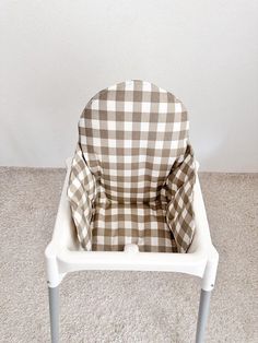 a white chair with a brown and white checkered seat cover on it's back