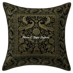 a black and green pillow with an ornate design on the front, featuring two birds